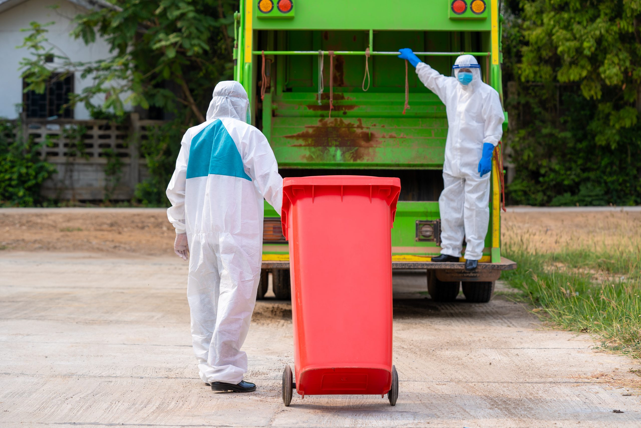 Two garbage men in hazmat PPE protective clothing wear medical r