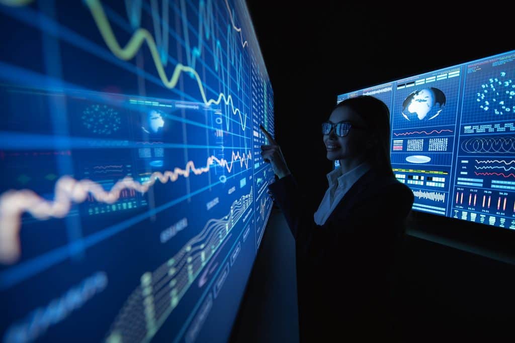 Woman Analyzes DIWASS Data on Large Digital Screens
