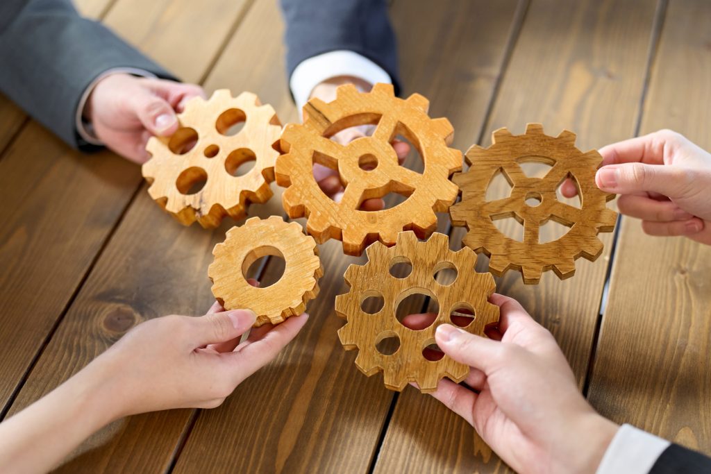 Teamwork Concept with Gears on a Wooden Surface
