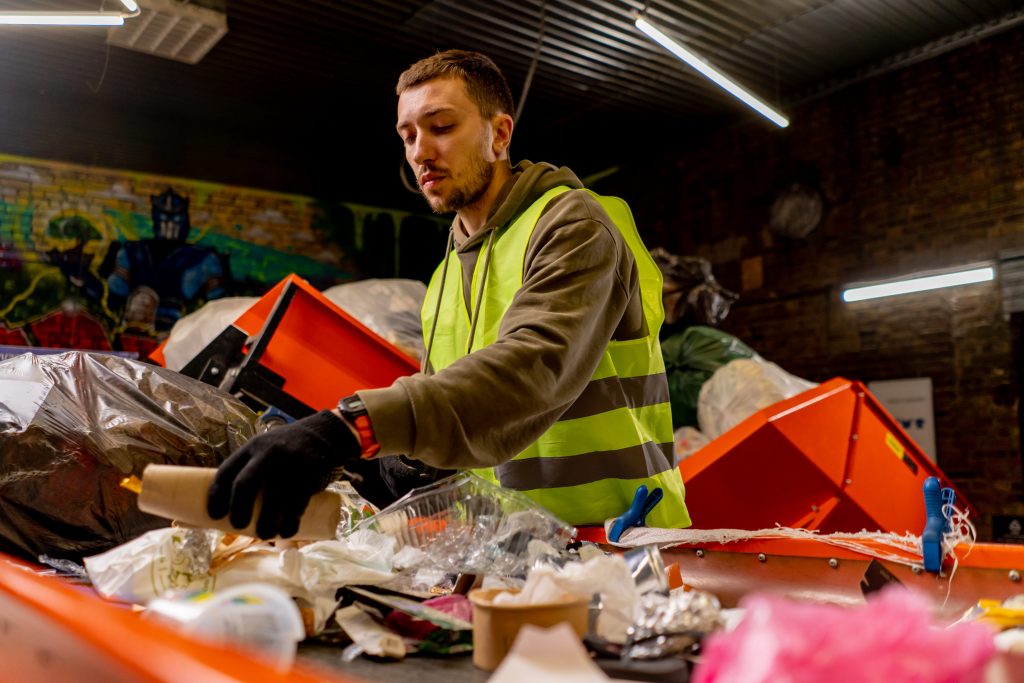 An employee in a uniform at a waste station