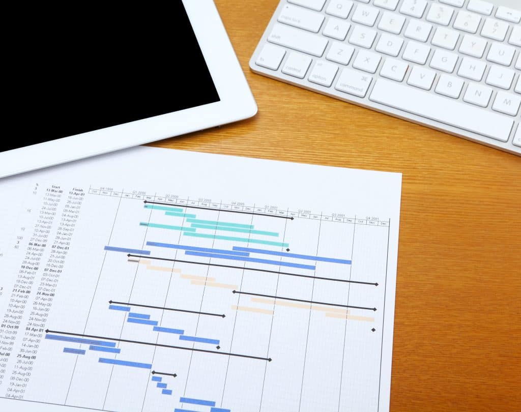 Project Planning and Technology on a Wooden Desk
