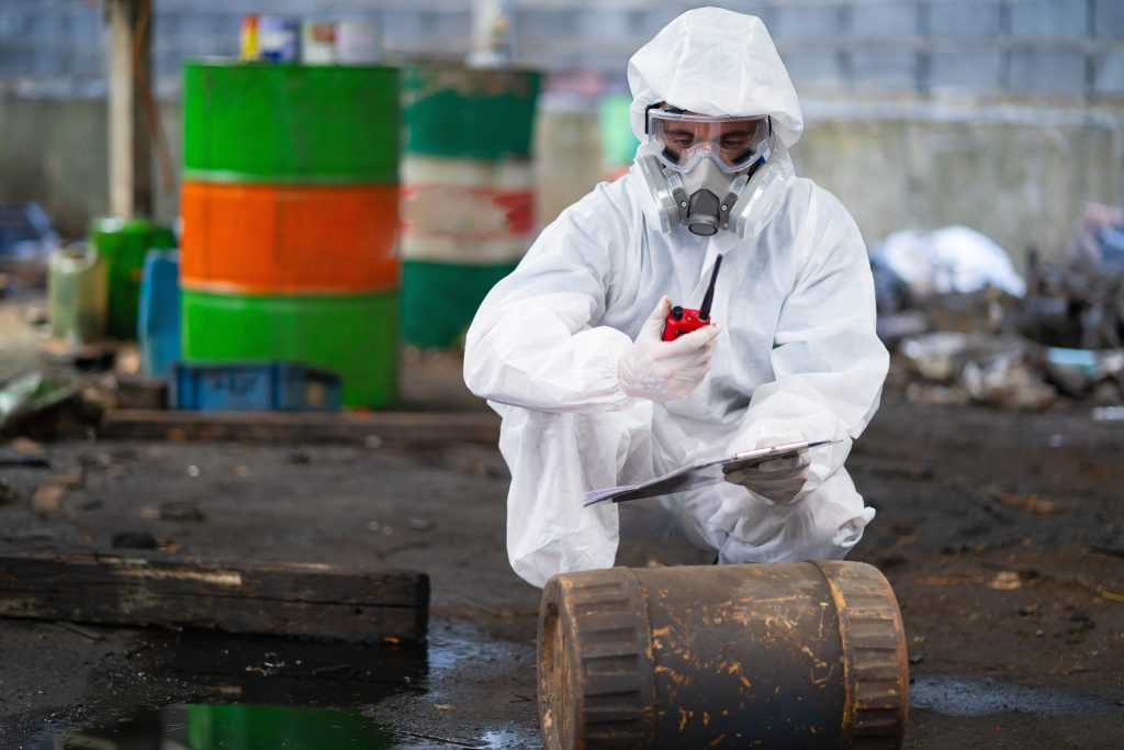 Technician in Protective Suit Inspects Hazardous Waste Site