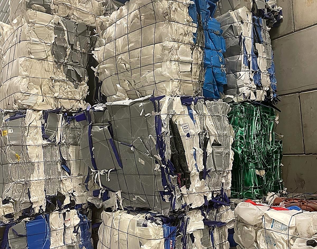Sorted and baled plastic film and packaging waste stacked at a material recovery facility
