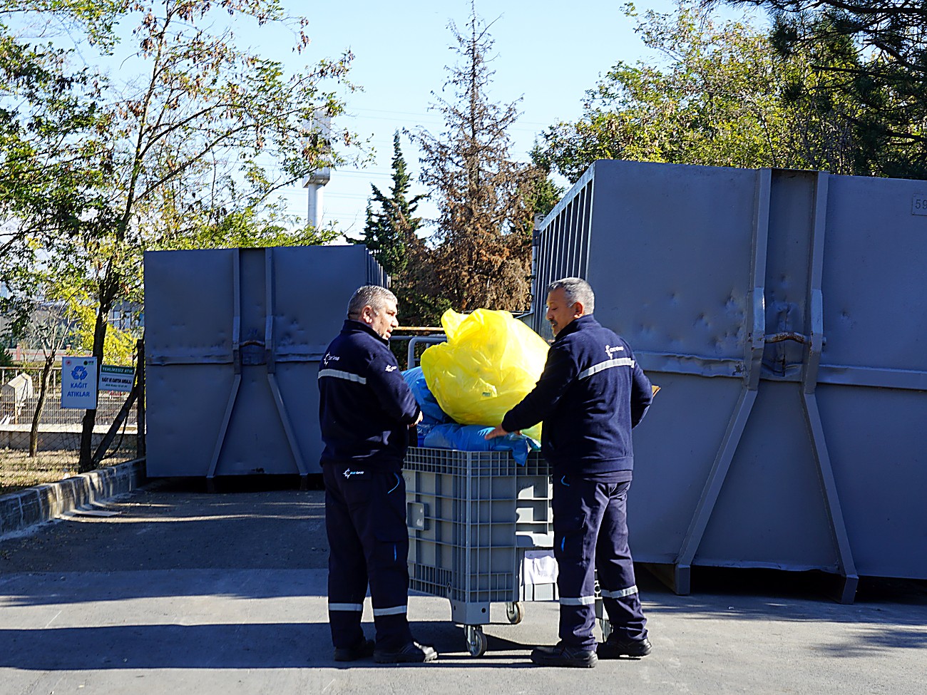 Municipal collection crew loading waste into a container during a routine collection round