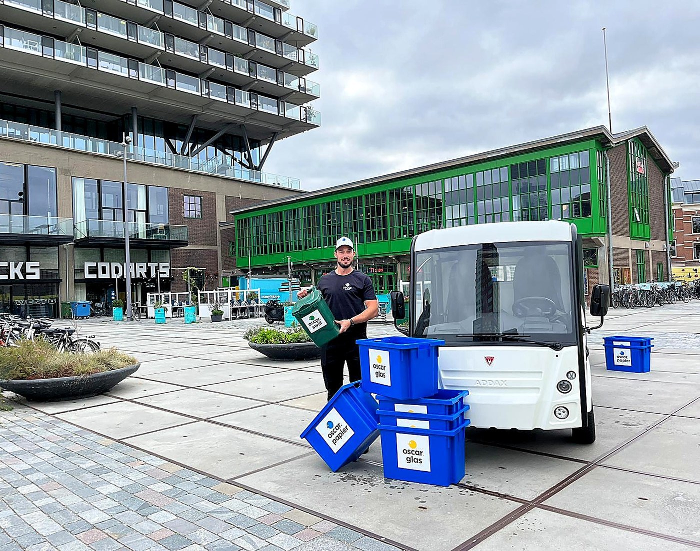 Branded commercial waste collection vehicle loaded with sorted recycling containers